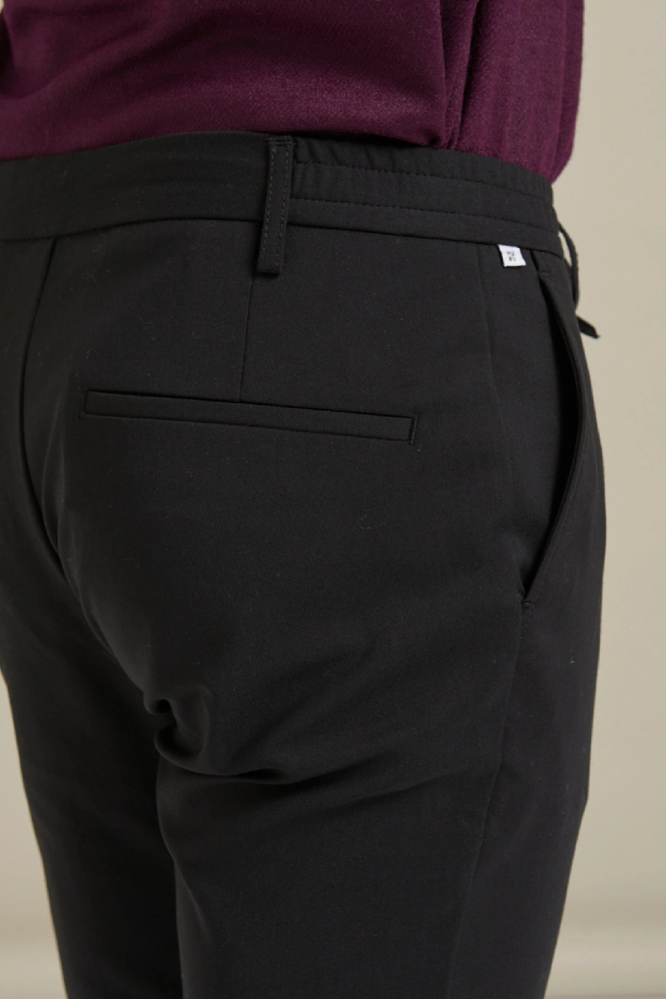 modelin üzerinde duran siyah Gentle Chino pamuklu pantolon arka cep görünümü.