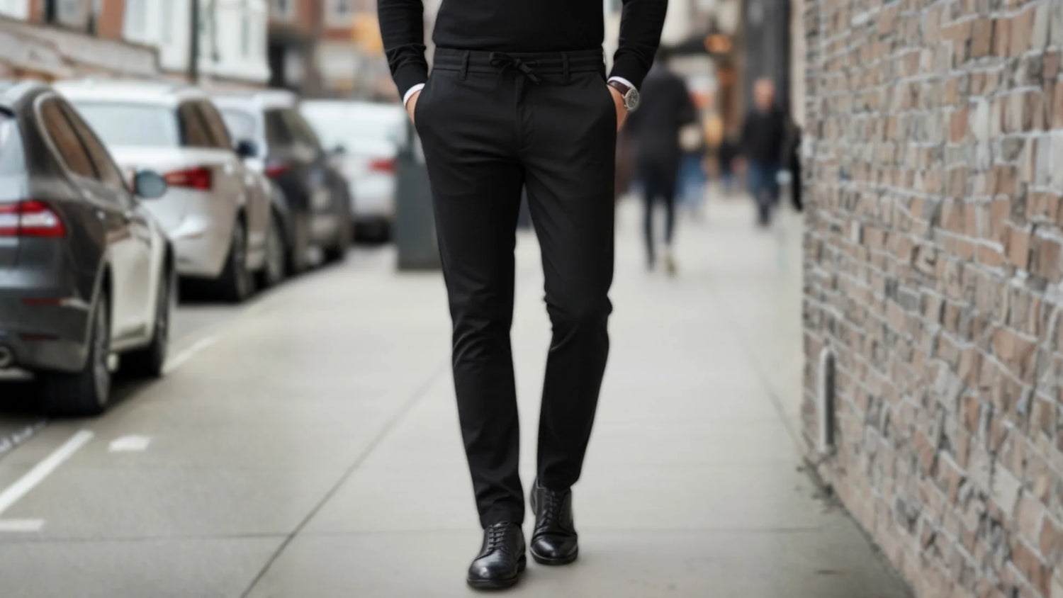 Siyah modern kesim erkek chino pantolon giymiş model sokakta yürüyor.