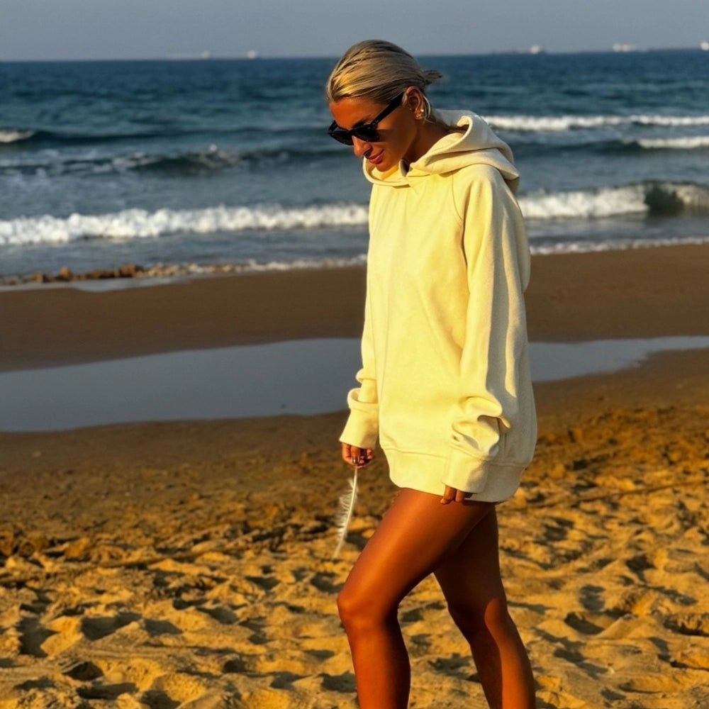 Soft Touch Hoodie | Unisex Kapüşonlu Sweatshirt – Ecru sahilde kadın manken üzerinde moda çekimi.