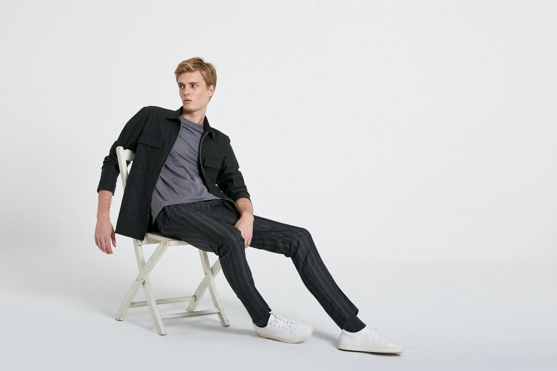 MUBU İstanbul premium erkek giyim koleksiyonu. Modern kesim koyu renk dış gömlek ve kumaş jogger pantolon kombiniyle oturan erkek model.