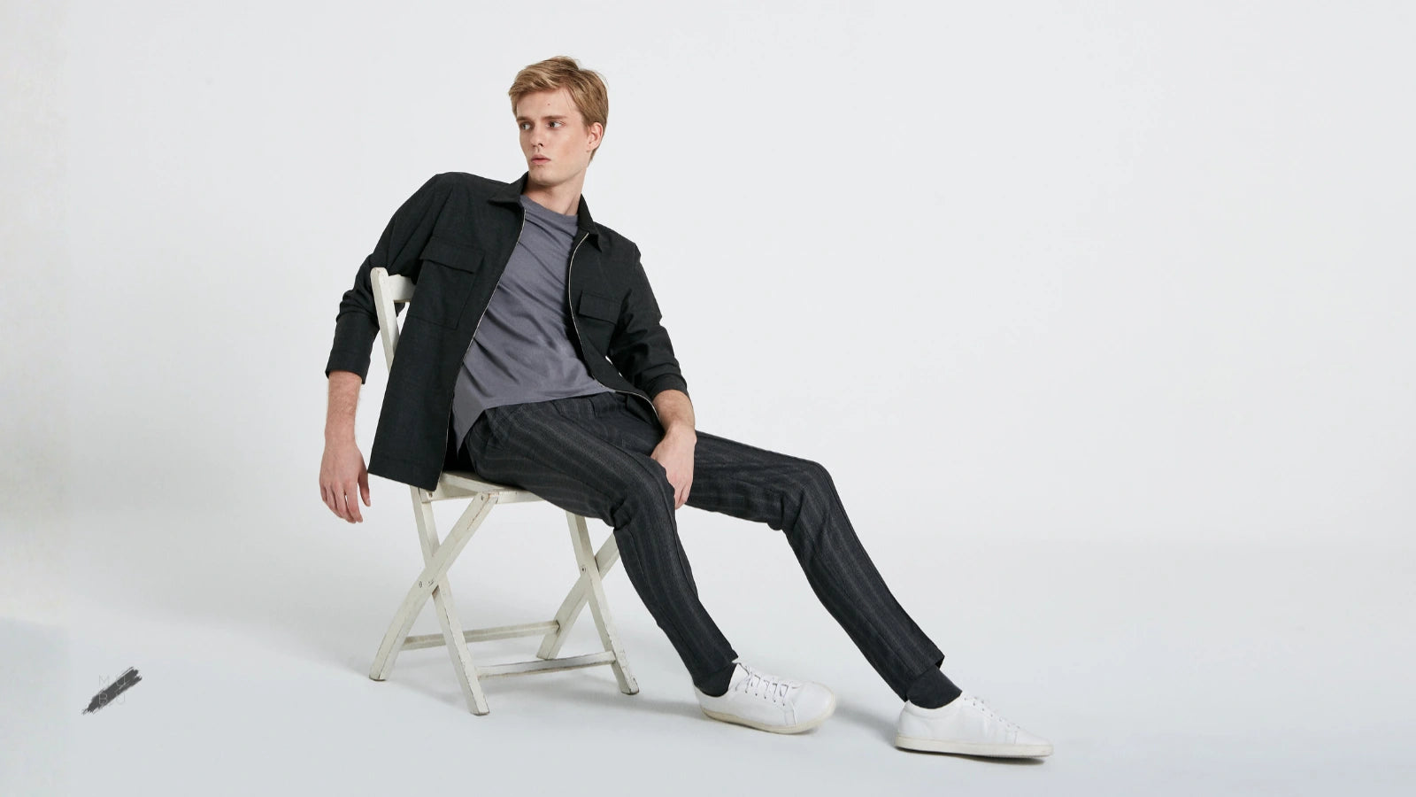 MUBU İstanbul premium erkek giyim koleksiyonu. Modern kesim koyu renk dış gömlek ve kumaş jogger pantolon kombiniyle oturan erkek model.