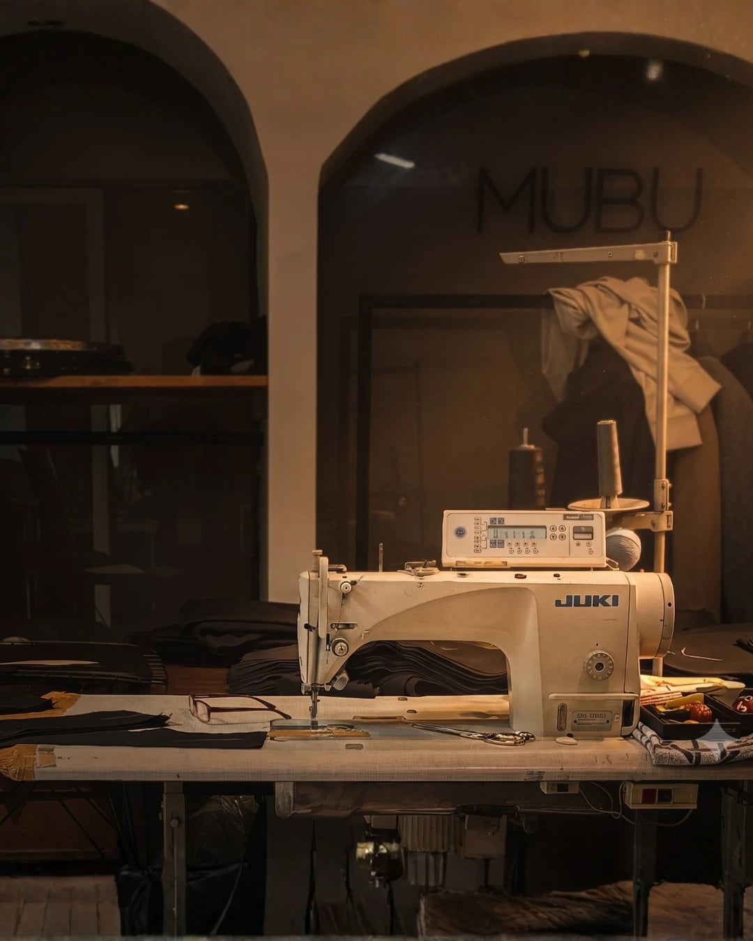 MUBU Staff Wear markalara özel kurumsal iş kıyafetleri ve premium personel üniforması üretim atölyesi. Profesyonel Juki dikiş makinesi ve tekstil masası.