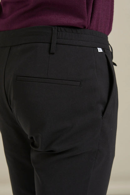 modelin üzerinde duran siyah Gentle Chino pamuklu pantolon arka cep görünümü.